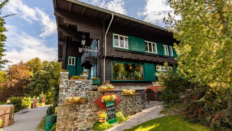 Looshaus am Kreuzberg, a traditional building with restaurant, surrounded by trees and garden.