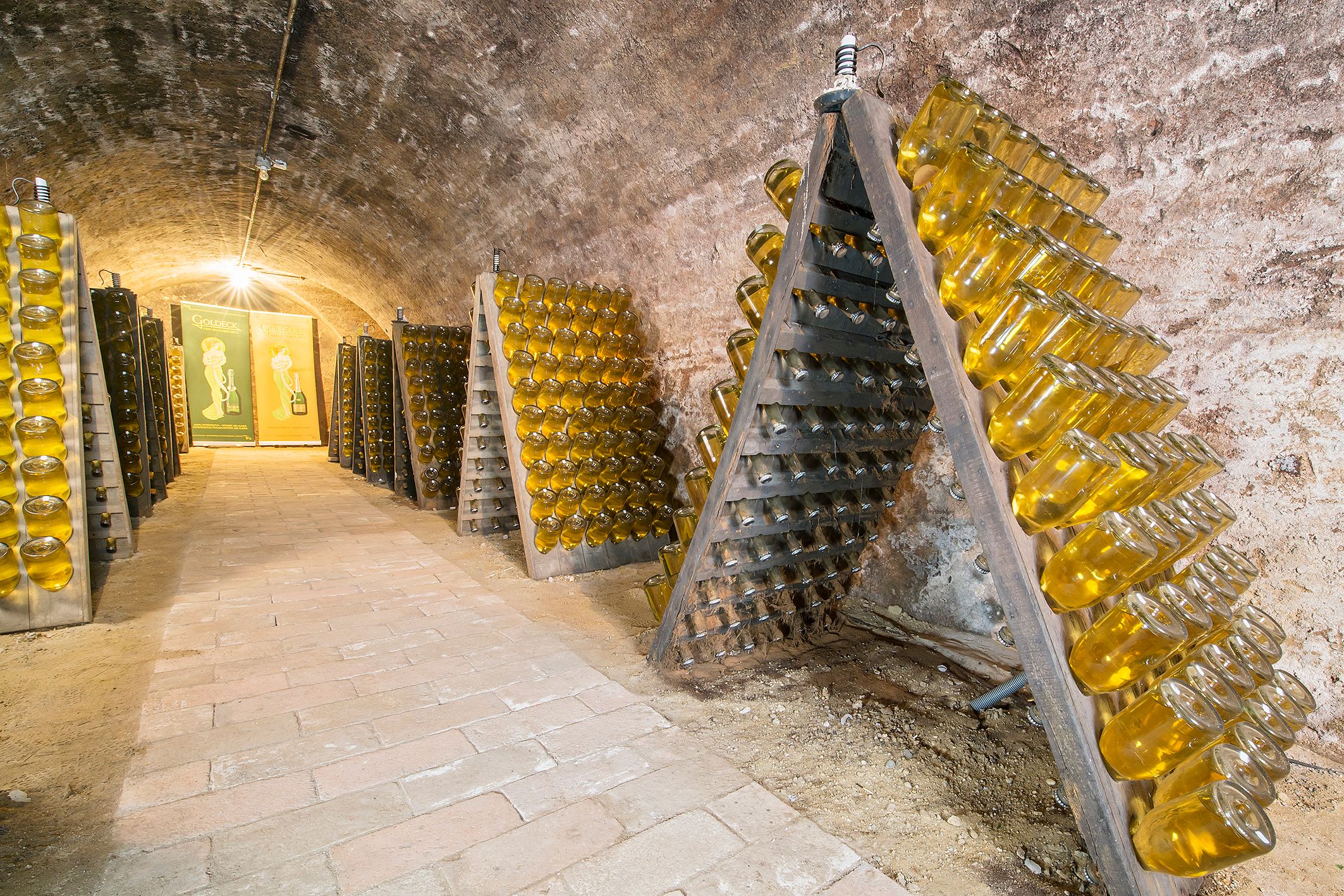 Wine cellar with sparkling wine bottles in shaking desks.