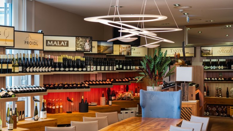 Interior view of a wine store with shelves full of wine bottles and modern lighting.