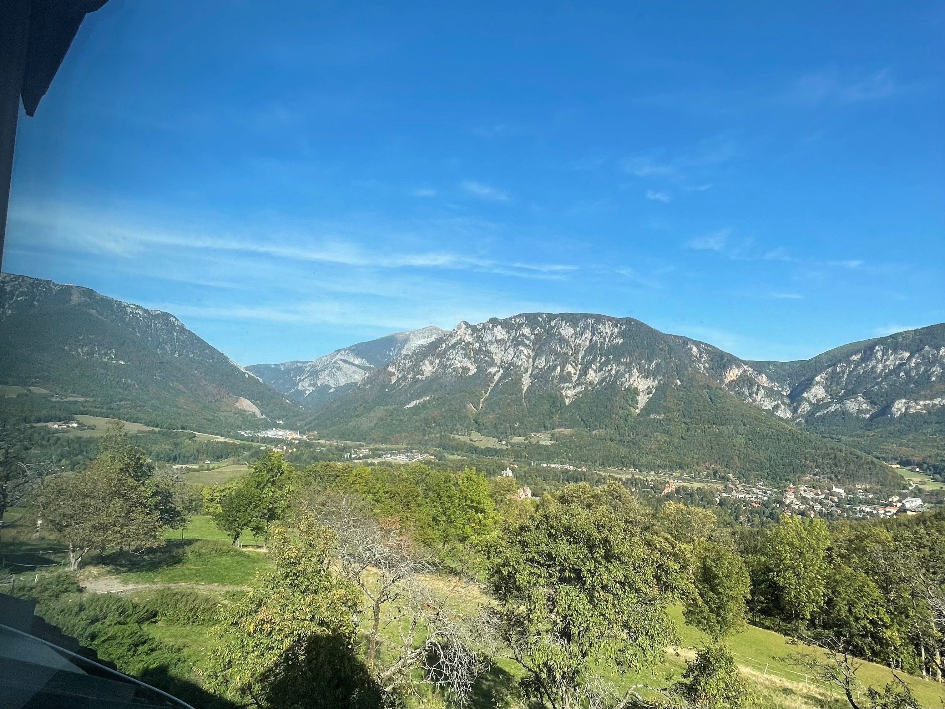 View of a mountain landscape with a blue sky and green meadows.