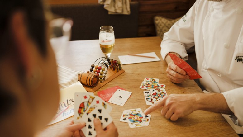Two people play cards in a cozy restaurant.