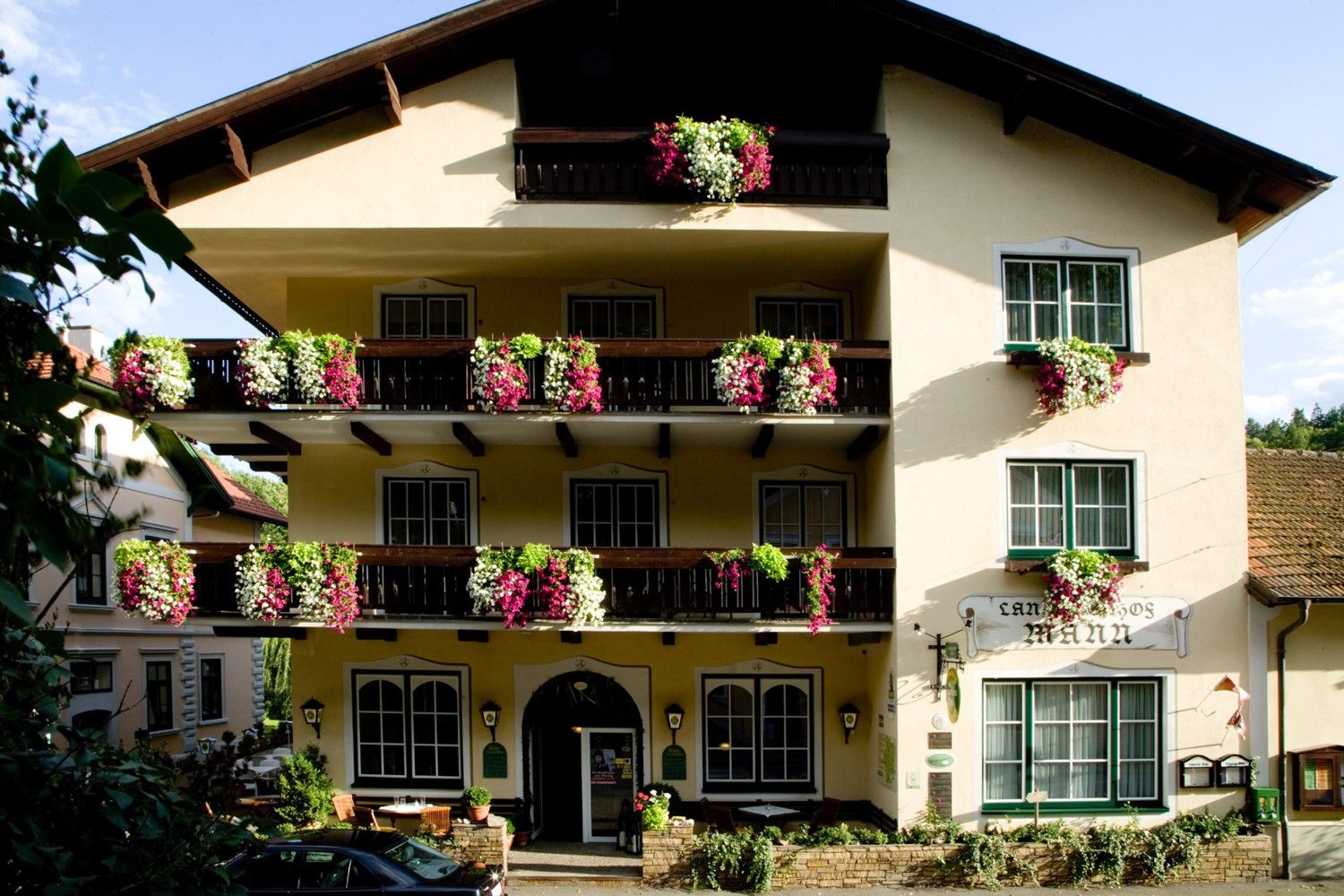 Facade of a traditional inn with balconies full of flowers.