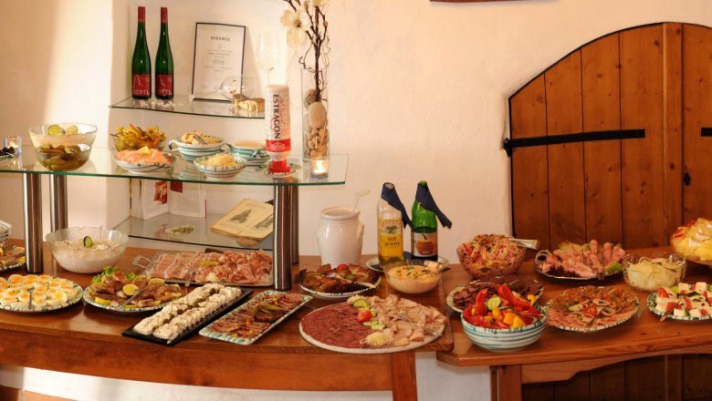 A buffet with various dishes and drinks on a wooden table.