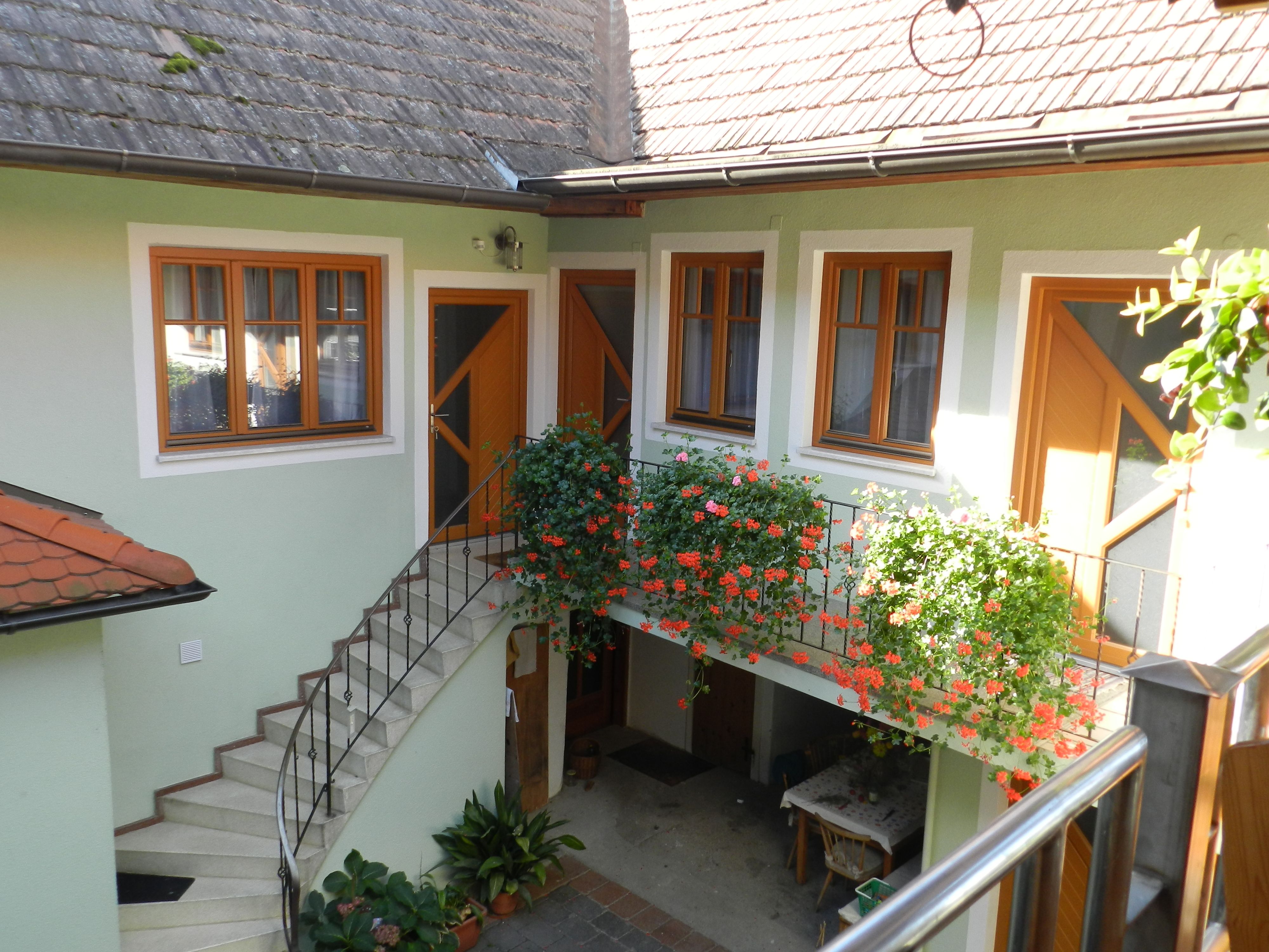Inner courtyard with stairs, flowers and table.