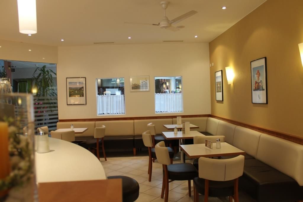 Interior view of a café with tables, chairs and wall decorations.