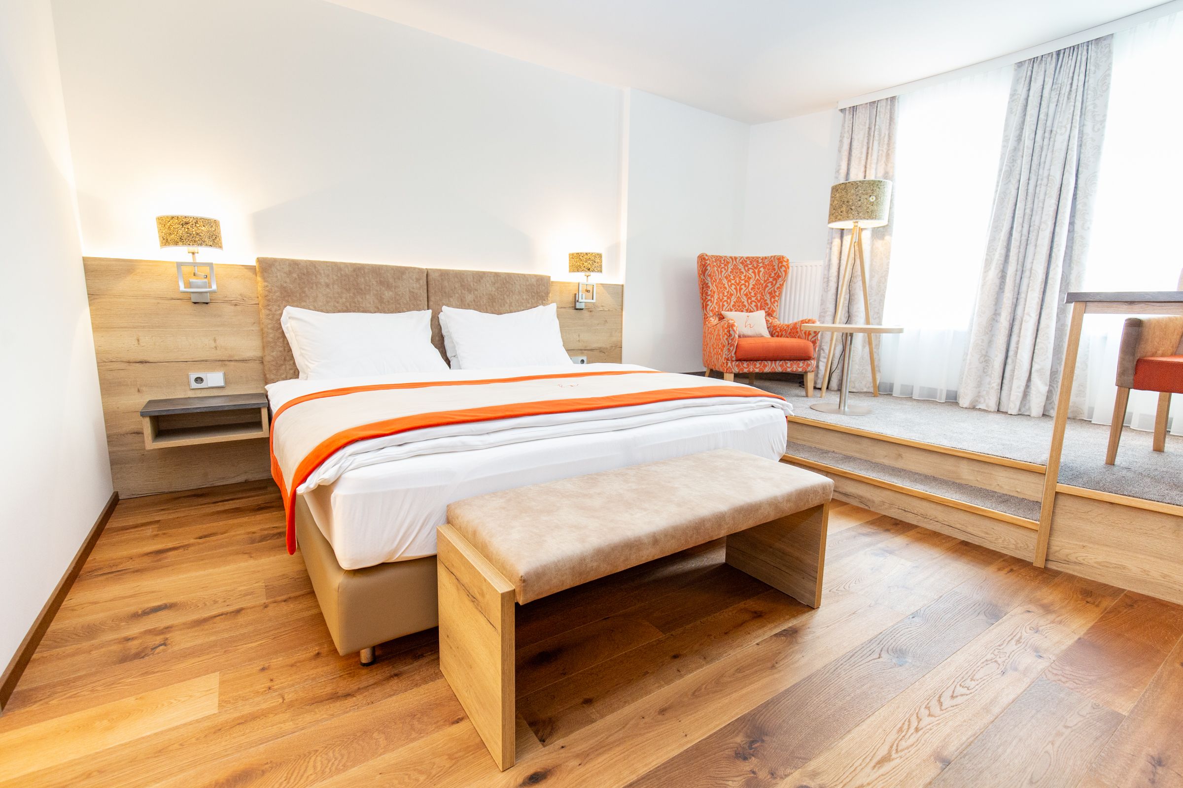 A modern double room with an extra reading and writing corner.