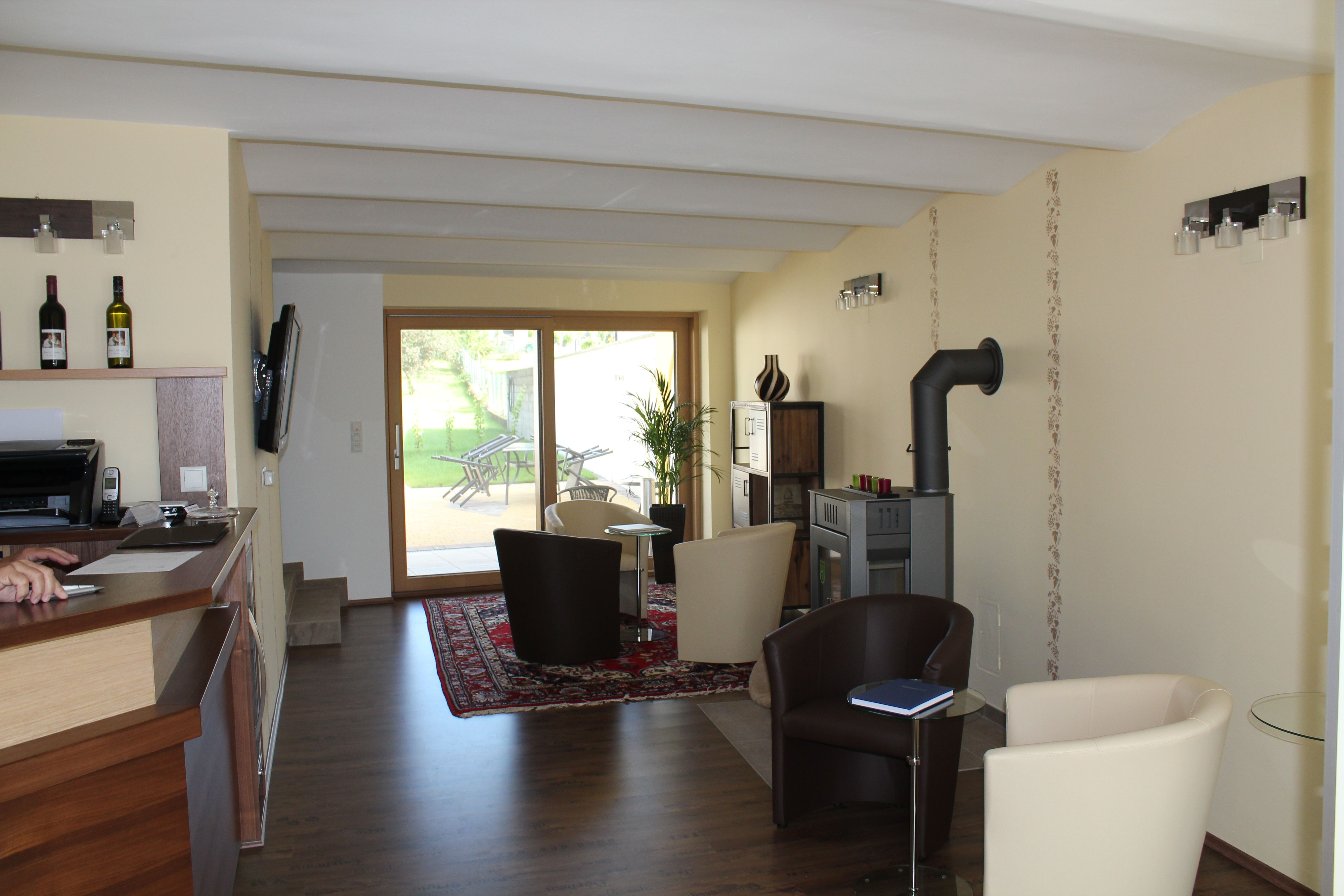 Interior view of a modern guest house with seating area, fireplace and glass door to the garden.