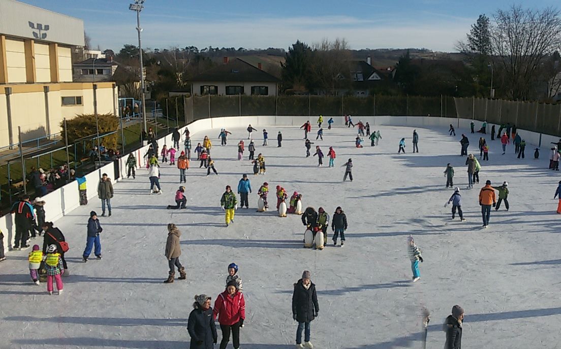 People ice skating on an open-air ice rink in Wolkersdorf.