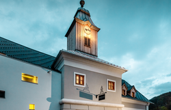 Das Hotel zum Glockenturm strahlt eine einladende Atmosphäre aus, während die sanften Farben der Fassade im Abendlicht leuchten. Die charmante Architektur und der markante Glockenturm laden dazu ein, die Umgebung zu erkunden und die Schönheit der Natur zu genießen.