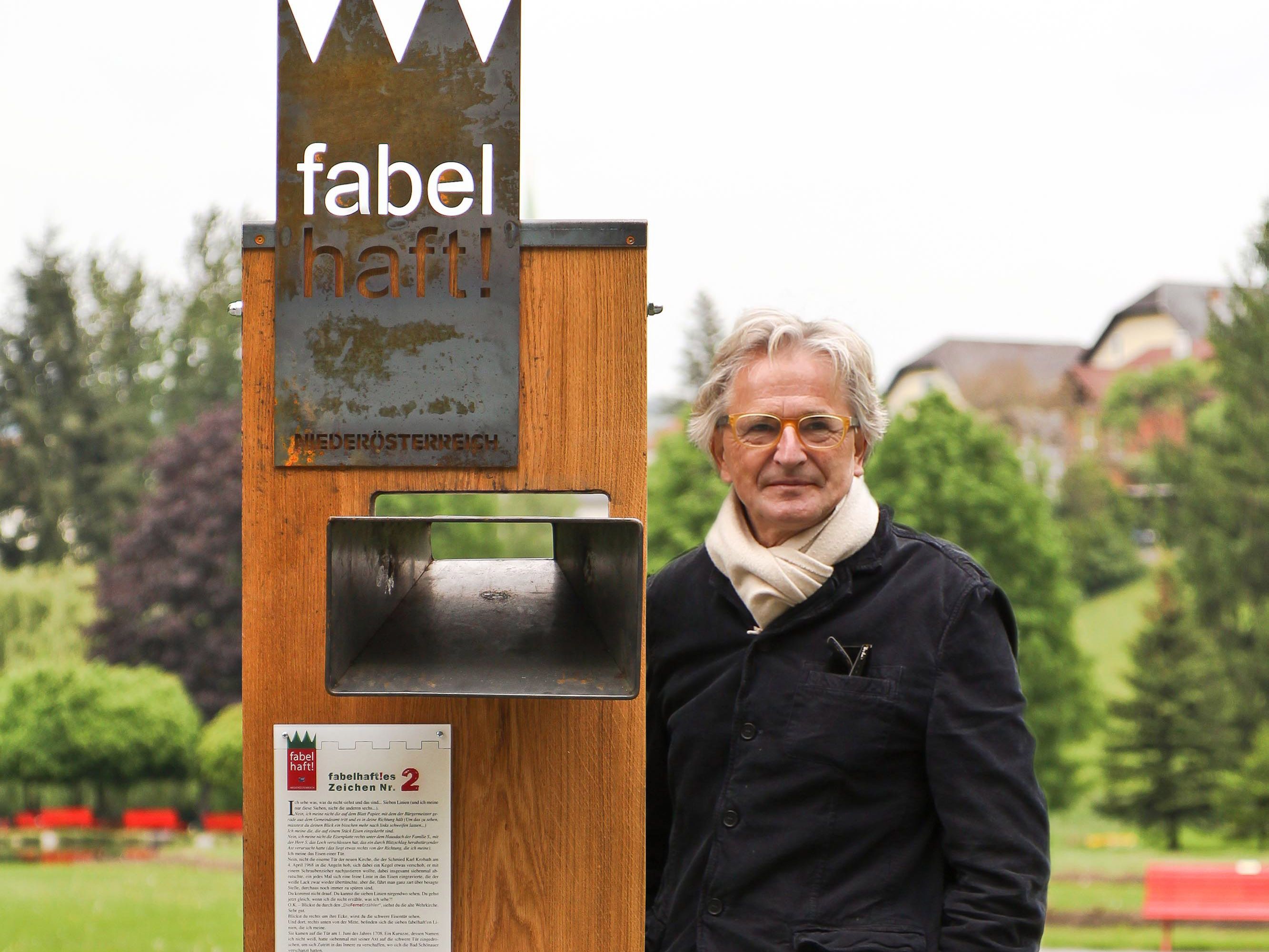 A man stands next to a wooden sign with the words 'fabulous' in a park.