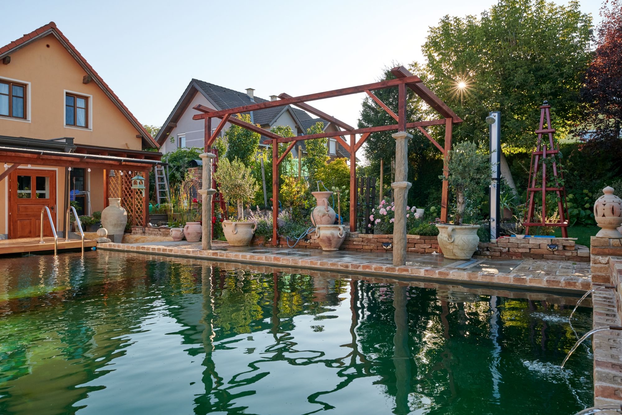A Mediterranean garden with pool, terracotta pots and wooden structures in the Weinviertel.