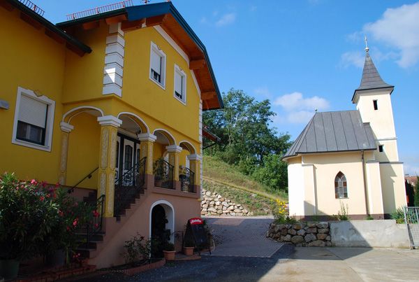 Yellow building with stairs and a small church next to it.