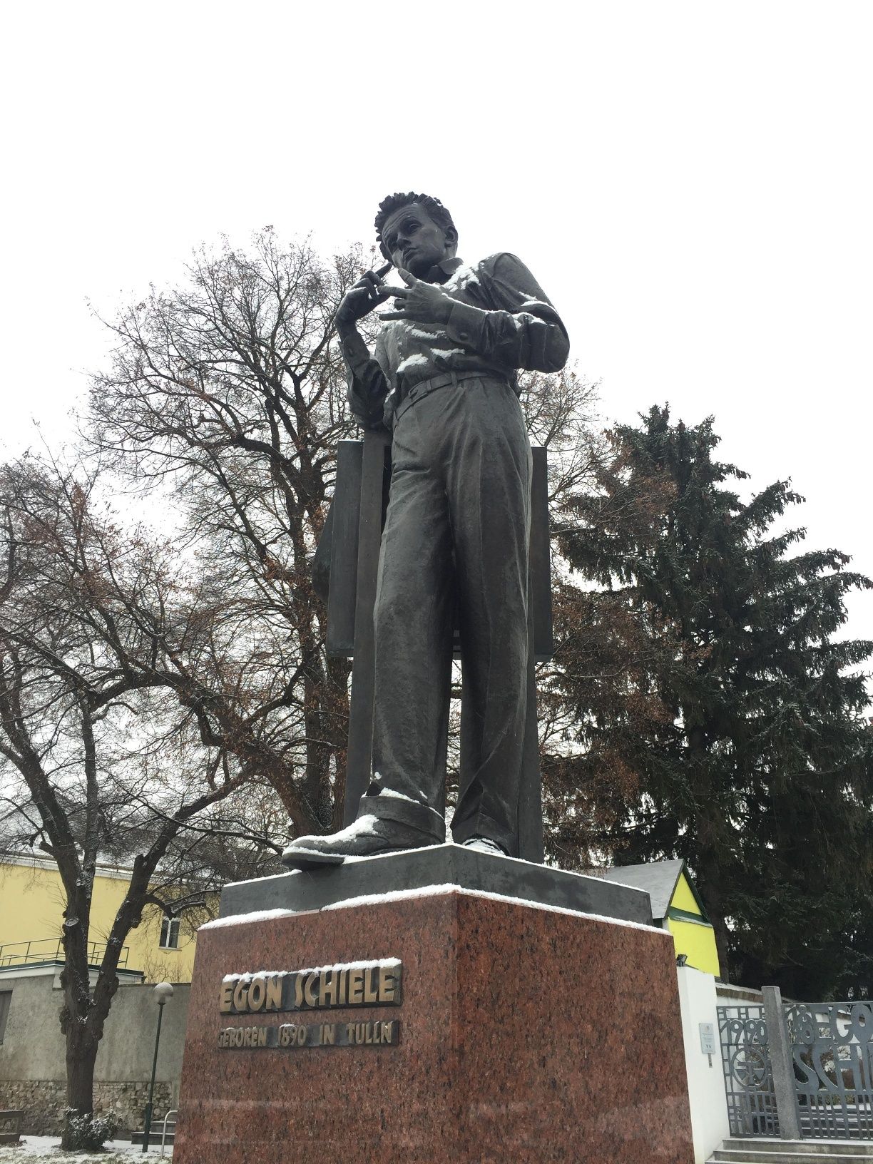 Statue of Egon Schiele in a snow-covered park.