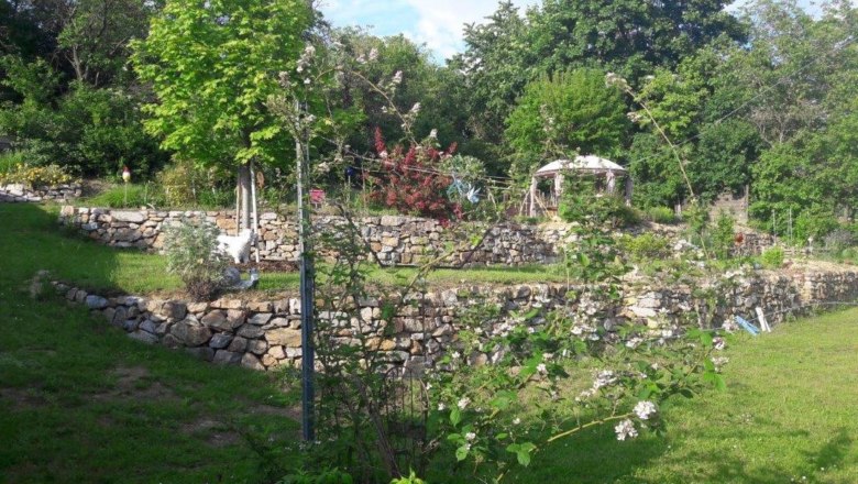 Terraced garden with stone walls and pavilion.