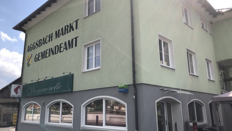 Green building with the inscription 'Aggsbach Markt Gemeindeamt' and Café Donauwelle.