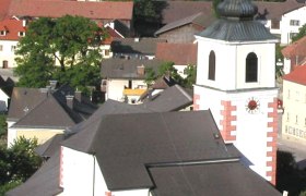 Hochneukirchen parish church with surrounding buildings and landscape.