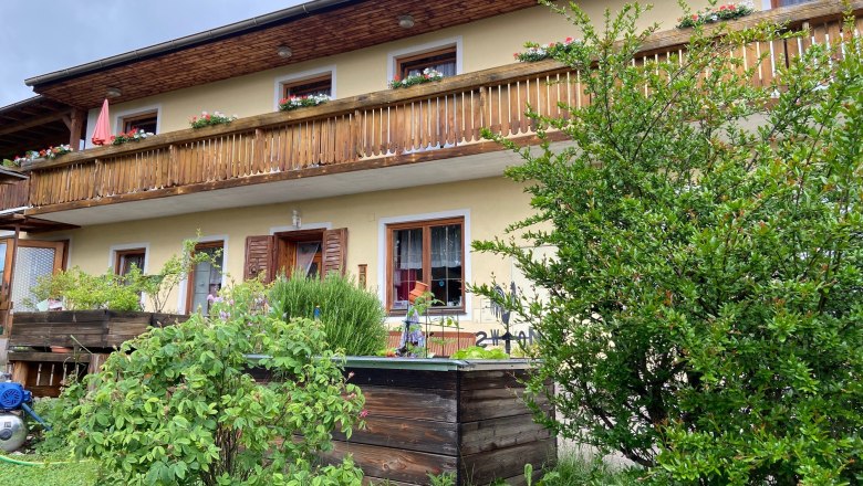 Private room family Berger, © Wiener Alpen Two-storey house with wooden balcony and garden.