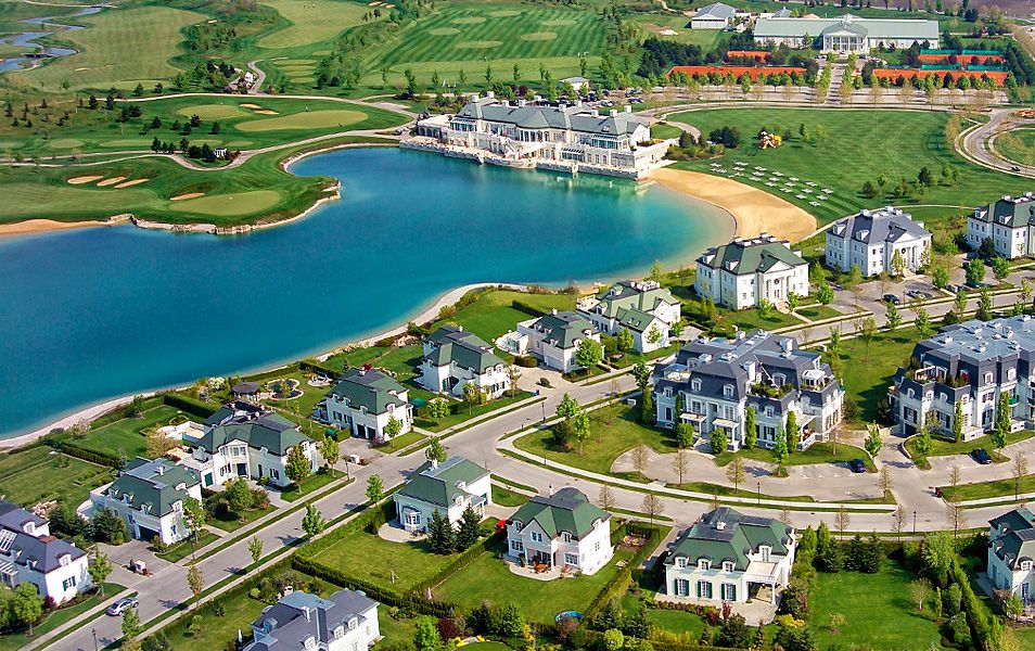Aerial view of Oberwaltersdorf with a lake, surrounded by villas and a golf course.