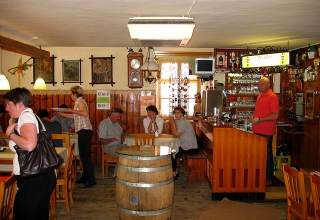 Interior view of a traditional inn with wooden furniture and bar.