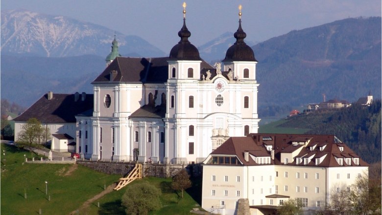 Sonntagberg basilica on a hill with mountains in the background.