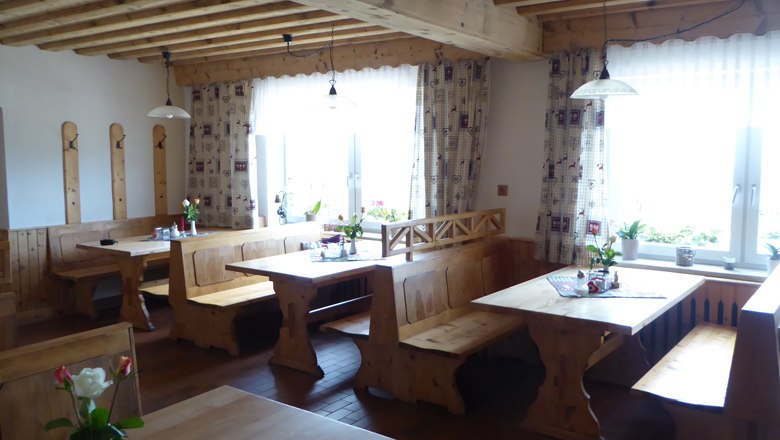 Cozy guest room with wooden furniture and flowers on the tables.