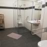 Barrier-free bathroom with shower, washbasin and grab rails.