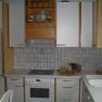 Kitchenette with stove, sink and cupboards in a vacation apartment.