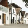 A couple strolls past traditional wine cellars.