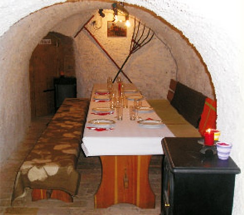 Cozy wine cellar with a laid table and rustic furnishings.