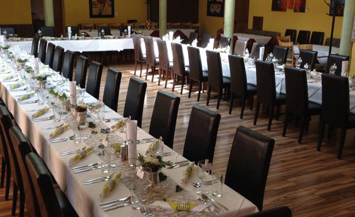 Festively decorated wedding table in a room with yellow walls and brick arches.