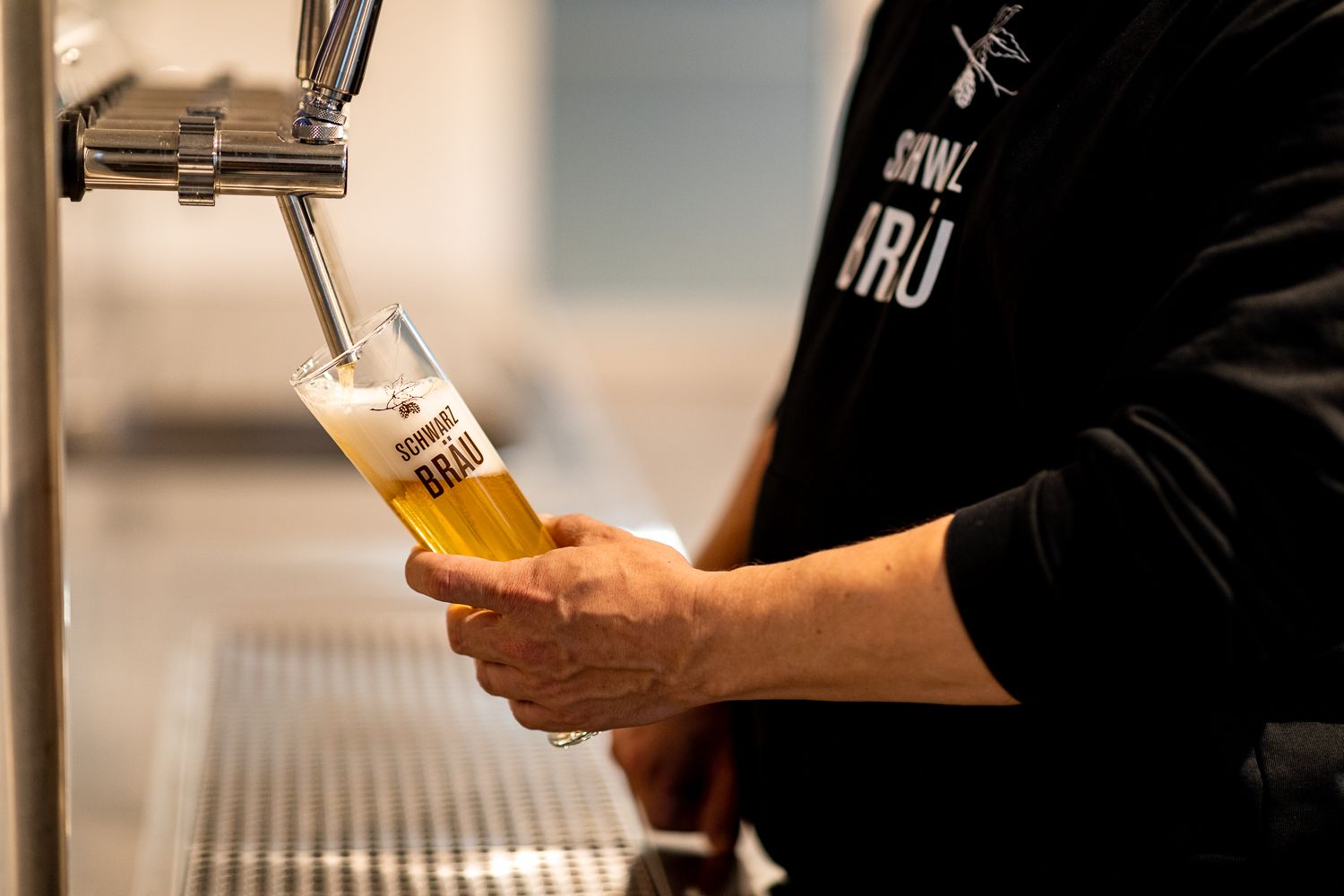 A person taps beer into a glass labeled "Schwarzbräu".