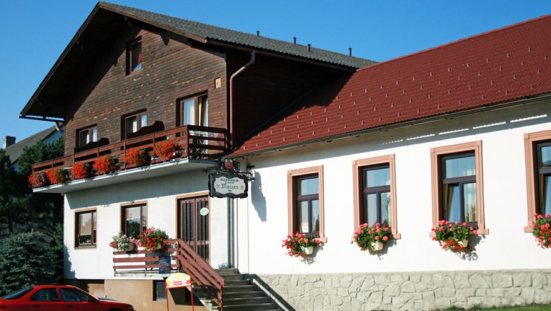 Gasthaus Malzer with flower-decorated balcony and windows.