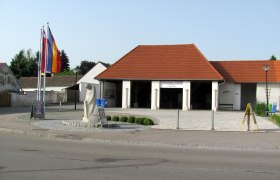 Exterior view of the brick museum in Ziersdorf with red roof tiles and flags.