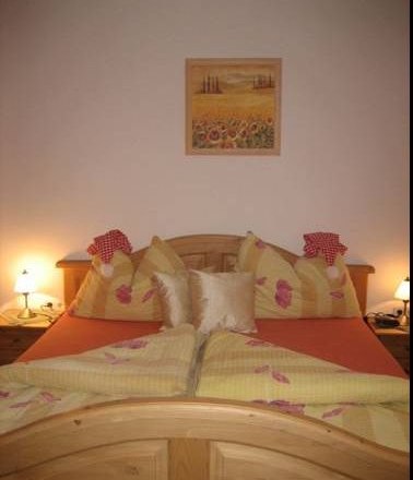Cozy guest room with double bed, decorative pillows and bedside lamps.