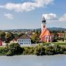 Landscape view of Persenbeug-Gottsdorf with church and river in the foreground.