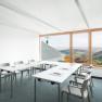 Seminar room with tables and chairs, large window overlooking the countryside.