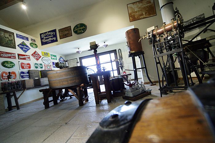 Interior view of the Wieselburg Brewery Museum with old brewing equipment and signs.