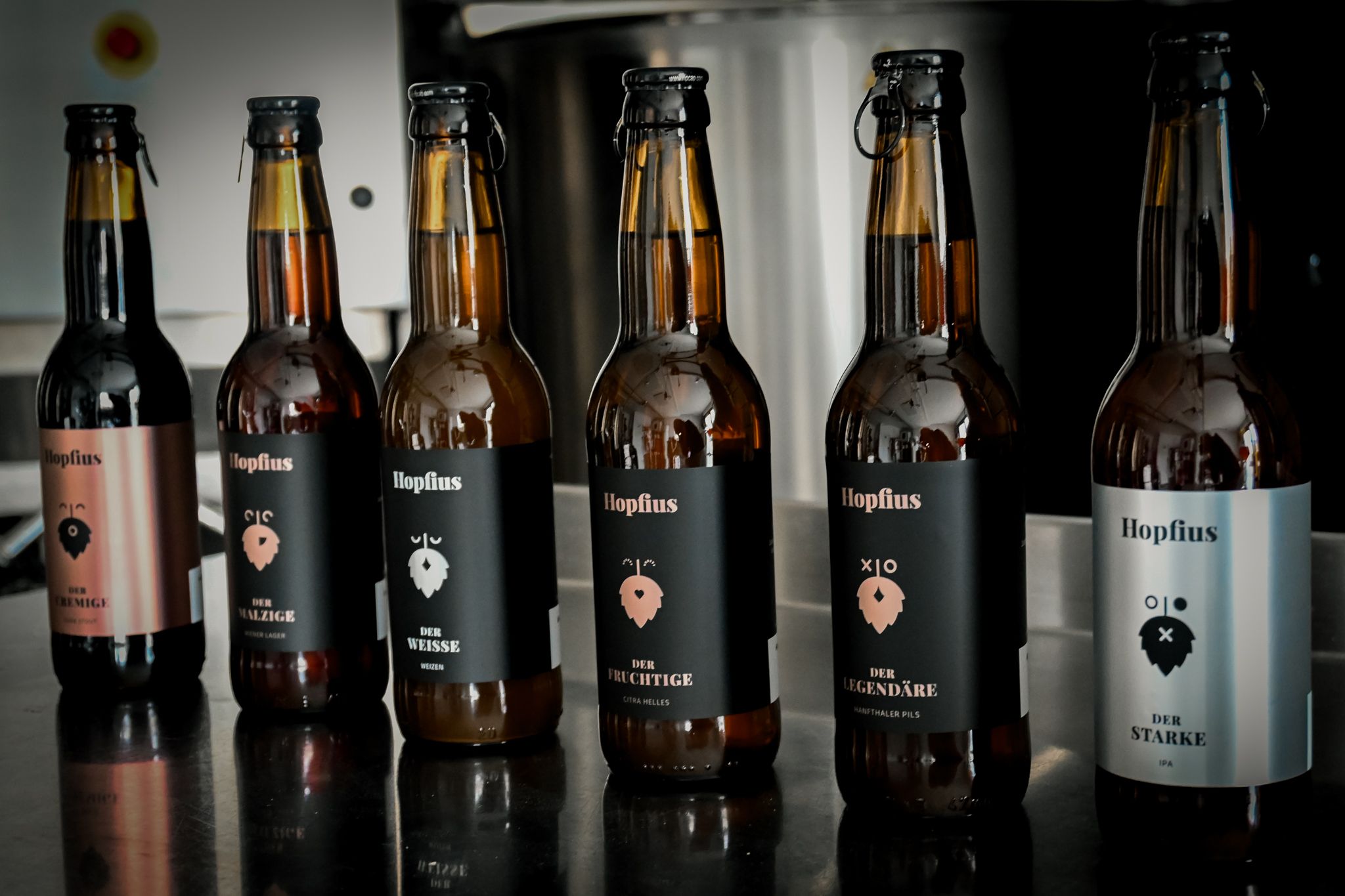 Six Hopflius beer bottles on a table.