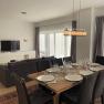 Modern living/dining area with dining table, chairs, sofa and TV.