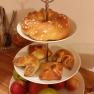 A three-tiered serving stand with pastries and fruit.