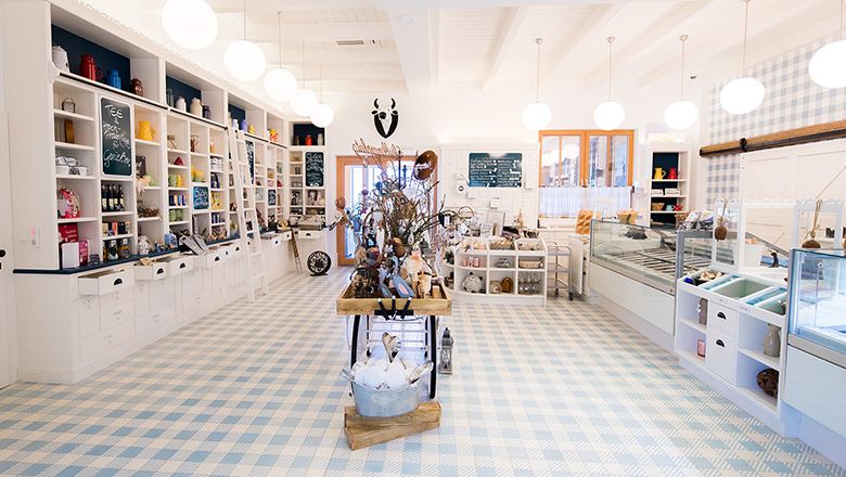 Interior view of a farm store with checkered floor, white shelves and ice cream display cases.