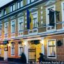 Exterior view of the Hotel Zierlinger with yellow façade and flags.