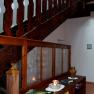 Wooden staircase in a loft with decorative elements and books on a shelf.