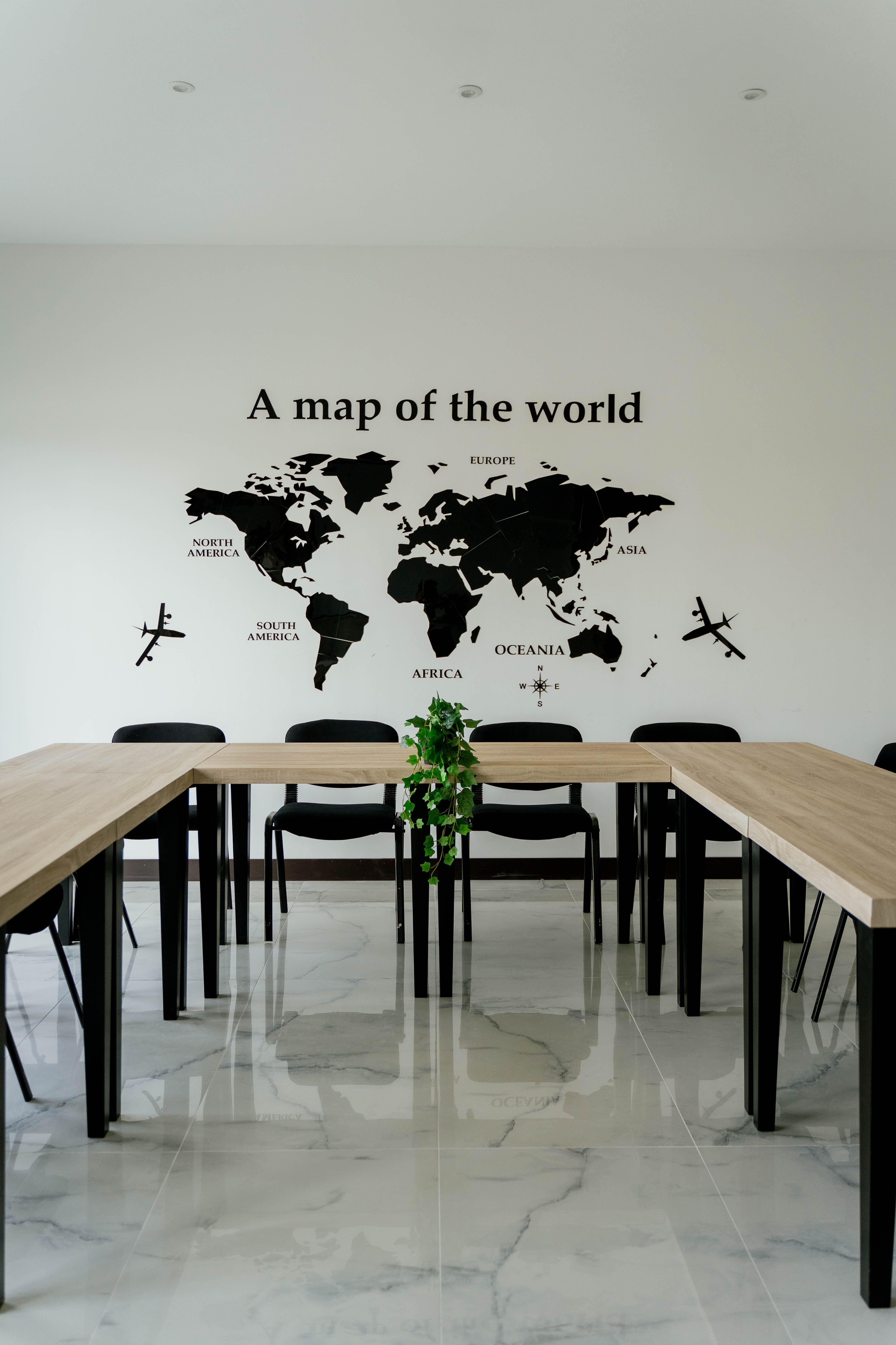 Conference room with a world map on the wall and U-shaped tables.