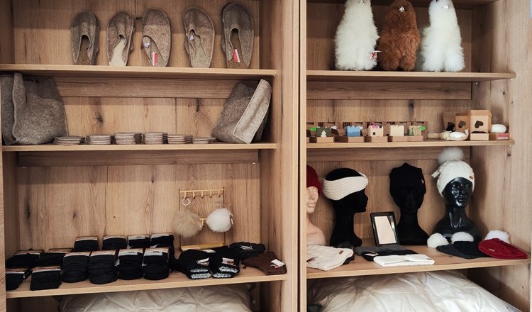 Shelves of felt slippers, hats, gloves and soft toys in a mobile farm store.