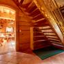 Wooden staircase in a house with wood paneling decorated with fairy lights.