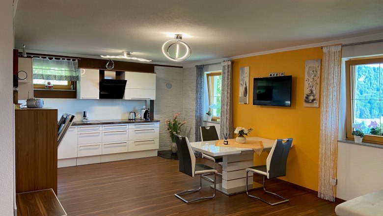 Modern eat-in kitchen with dining table, chairs and fitted kitchen.