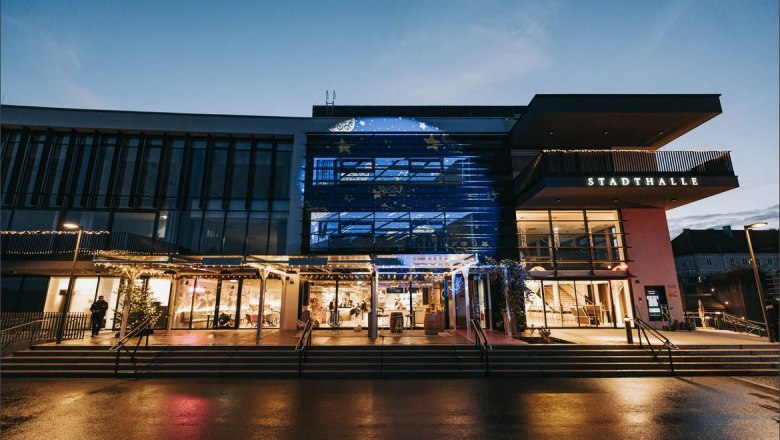 Exterior view of the Stadthalle Ybbs at dusk with illuminated entrance.