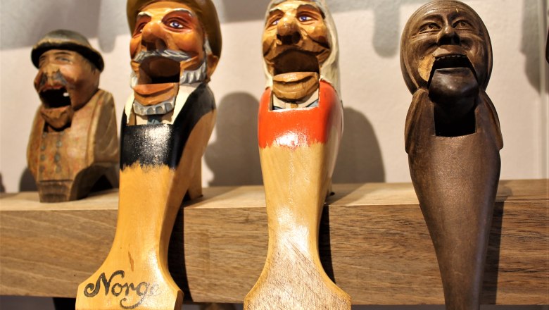 Wooden carved nutcrackers in the shape of heads on a shelf.