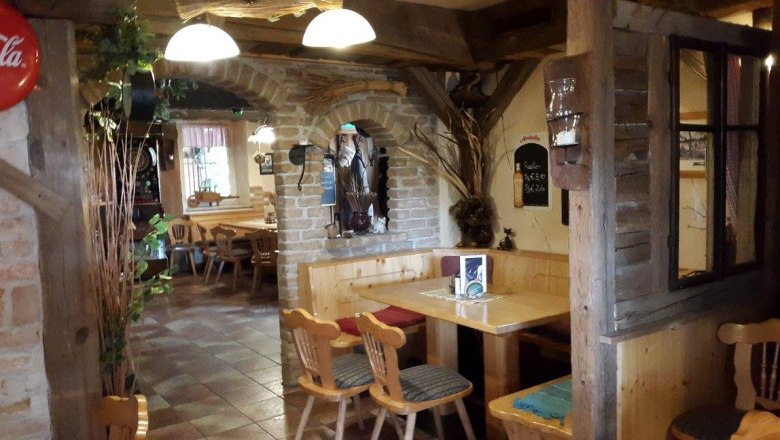 Cozy interior of a rustic pub with wooden furniture and brick walls.